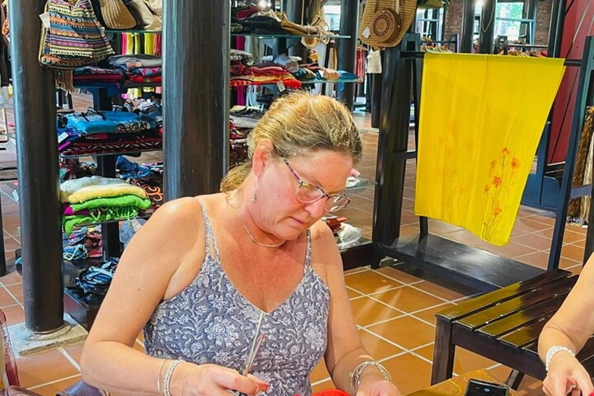 sieviete stāv veikalā un kaut ko skatās