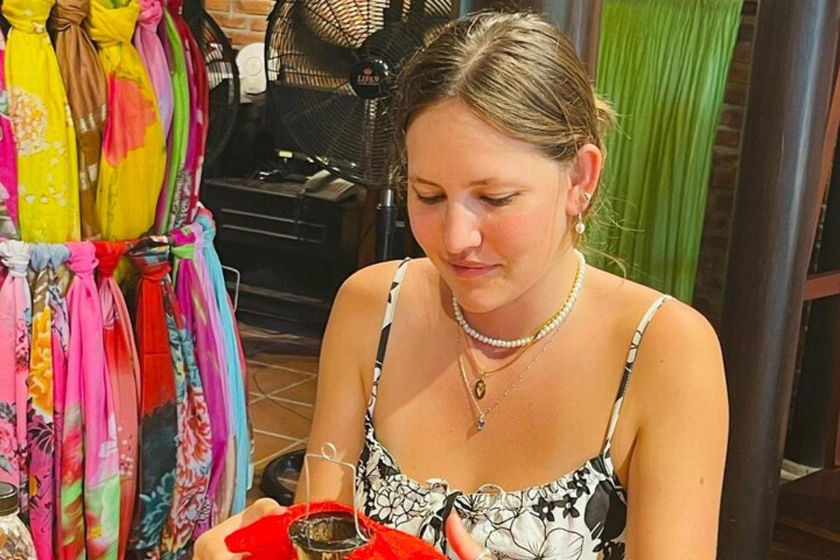 sieviete kleitā skatās uz savu mobilo tālruni