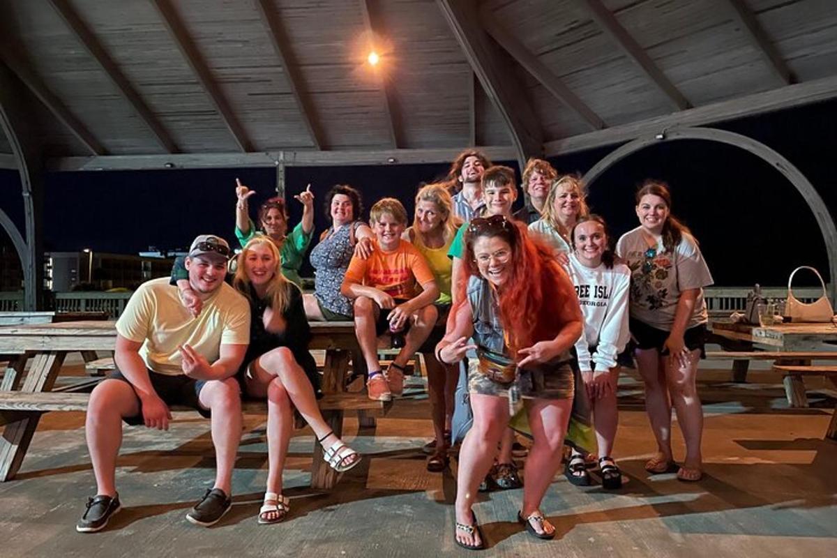 a group of people posing for a picture at a picnic table