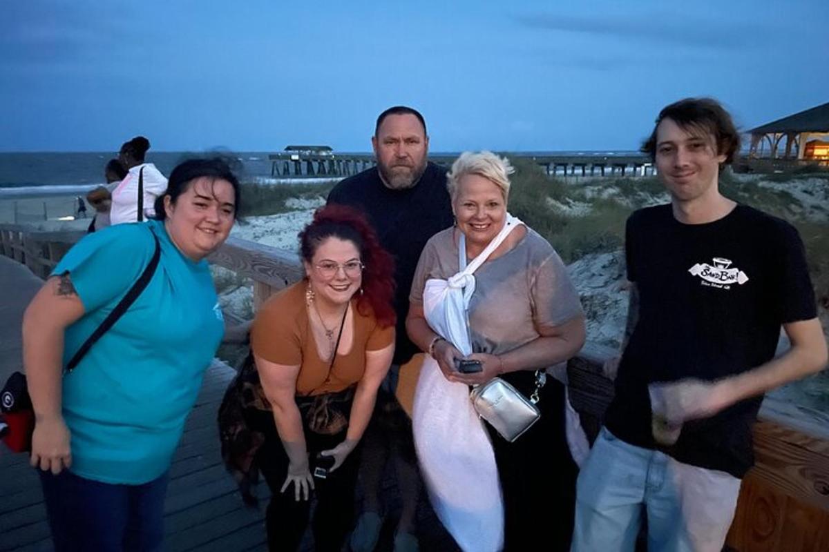 a group of people posing for a picture at the beach