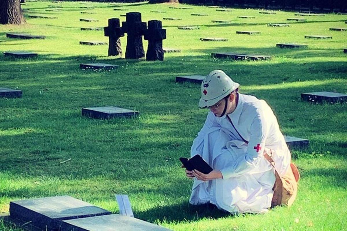 a man sitting in the grass looking at his cell phone