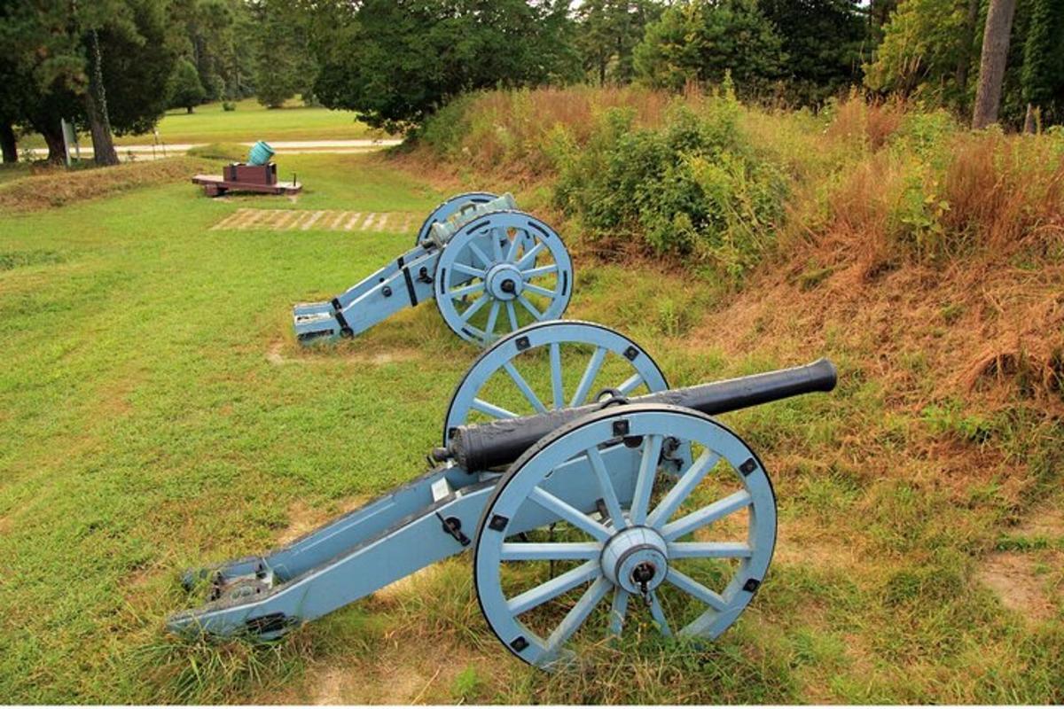 two old cannons sitting on top of a field
