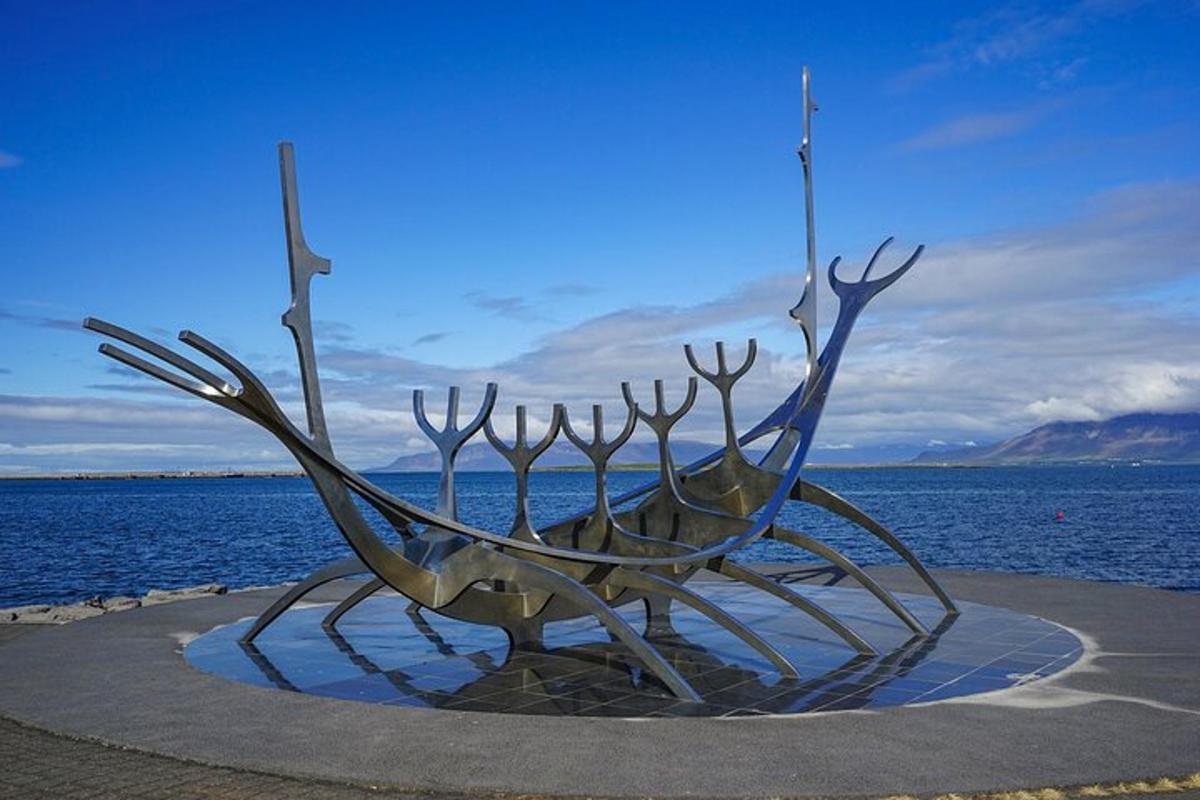 stytta af báti fyrir framan vatnið