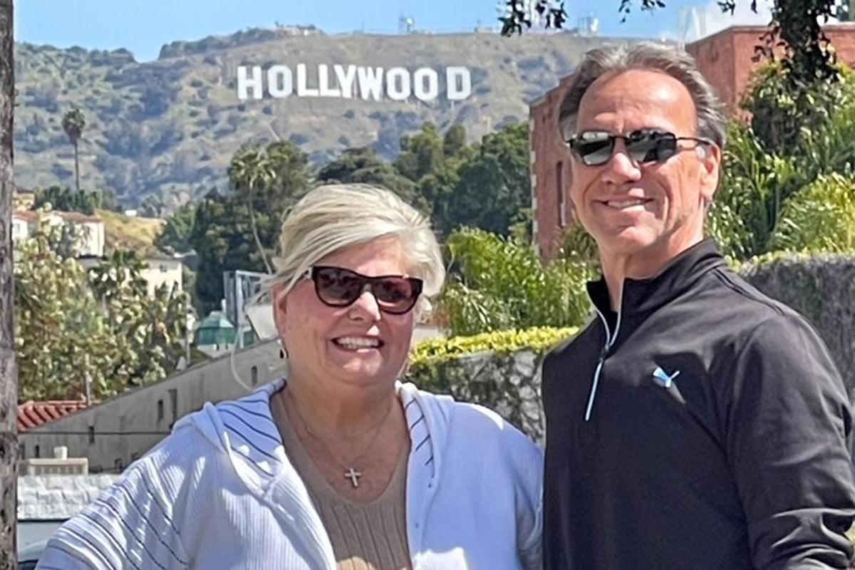 ein Mann und eine Frau stehen vor einem Hollywood-Schild