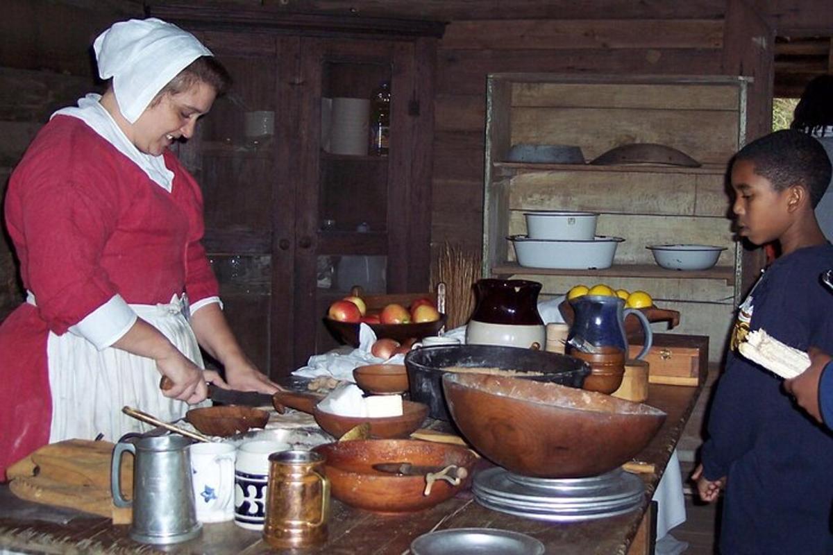 a woman preparing food in a kitchen with a child