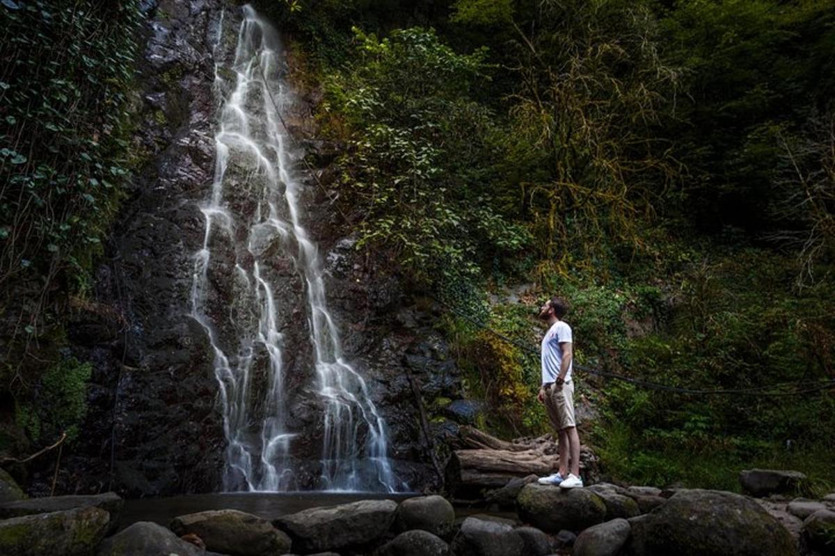 a man standing in front of a waterfall