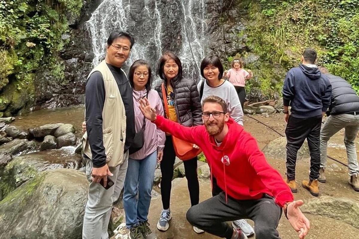 a group of people standing in front of a waterfall