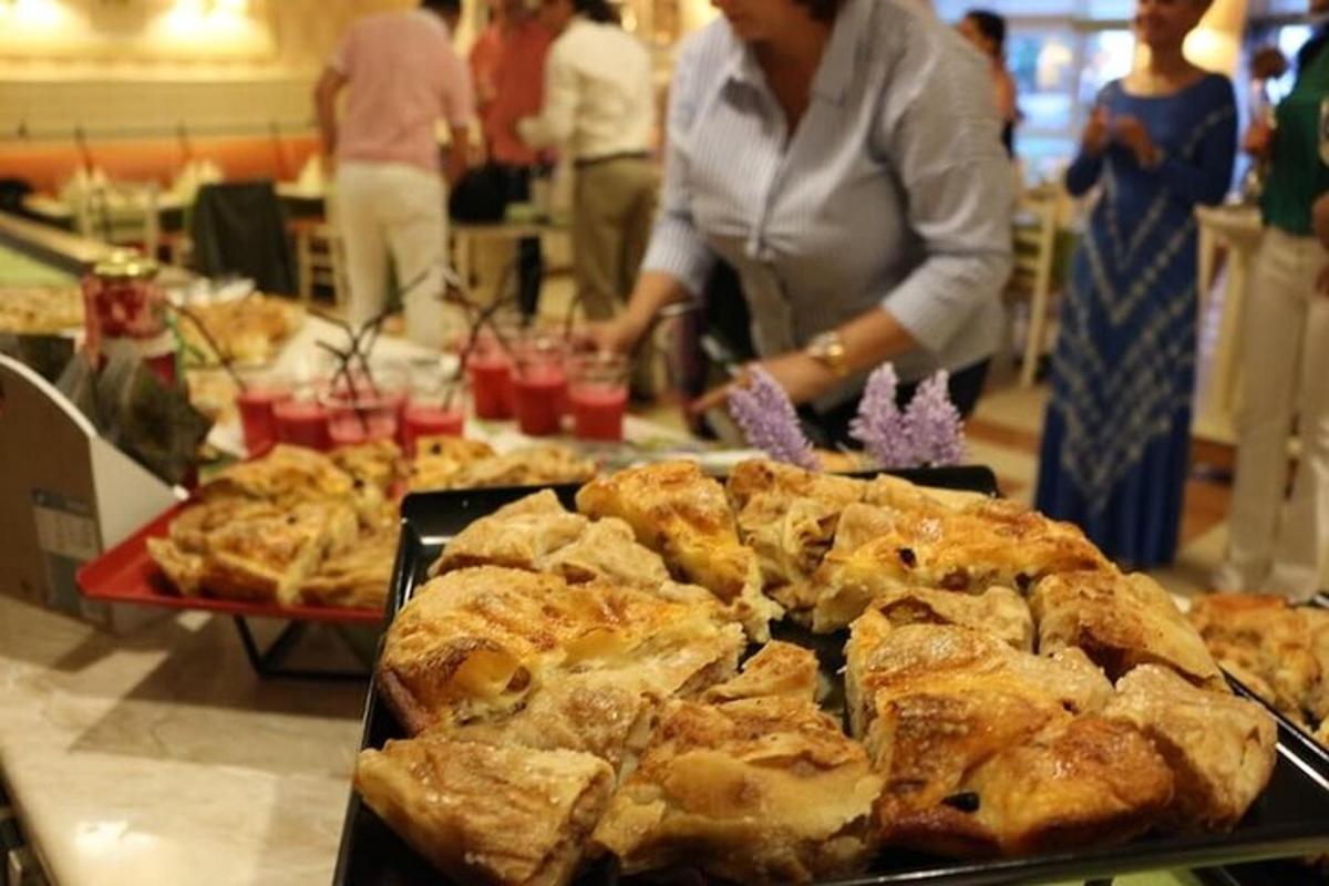 žena stojící před stolem s pizzou