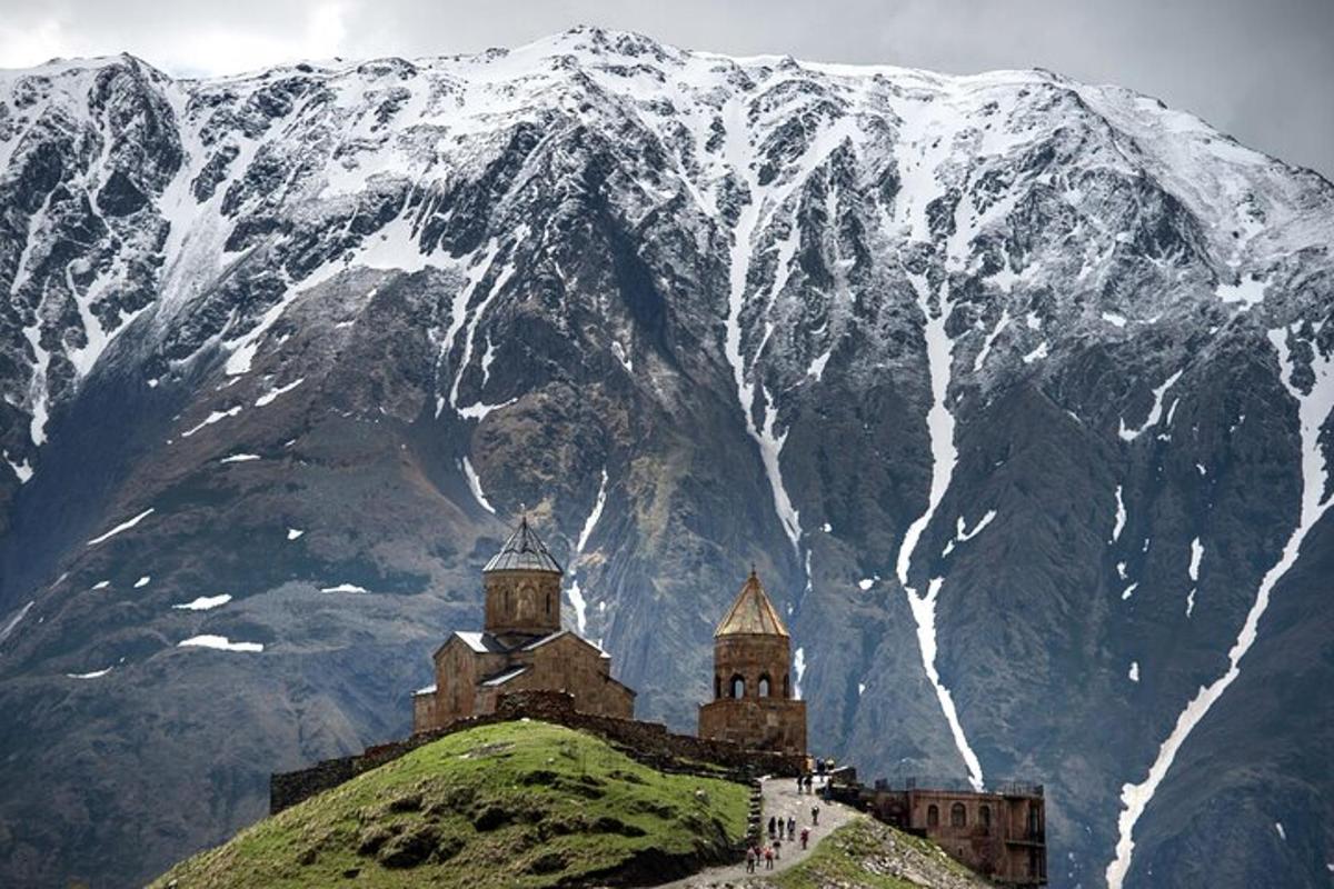 un castel pe un deal cu un munte acoperit de zăpadă
