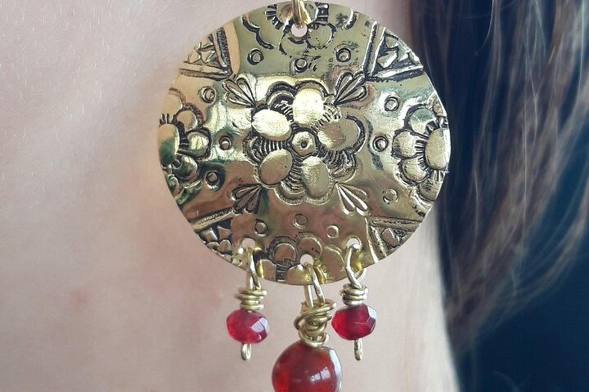 a woman is wearing a necklace with red beads on it