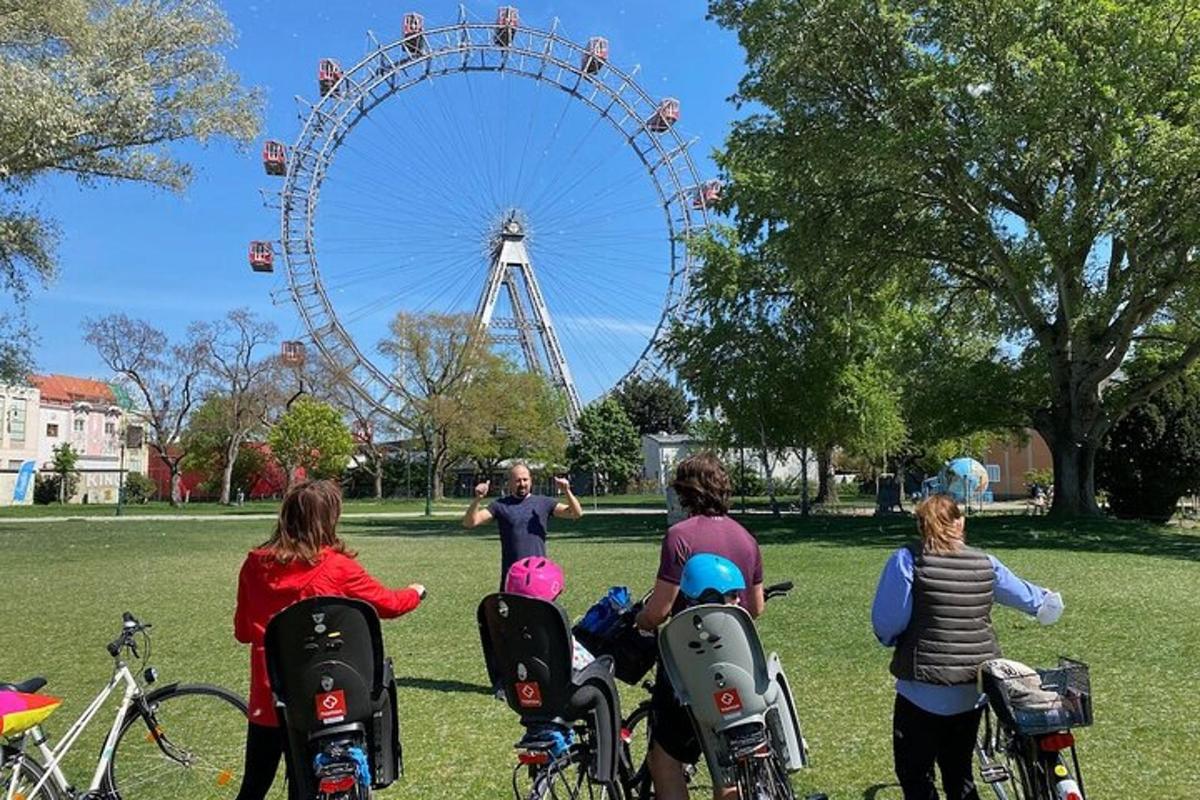en grupp människor som sitter på cyklar framför ett pariserhjul