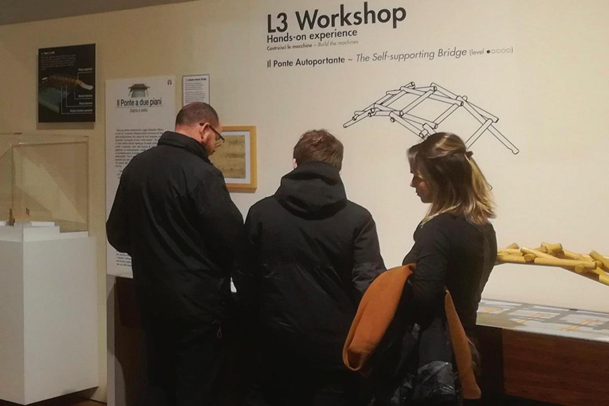 un gruppo di tre persone che guardano una mostra in un museo