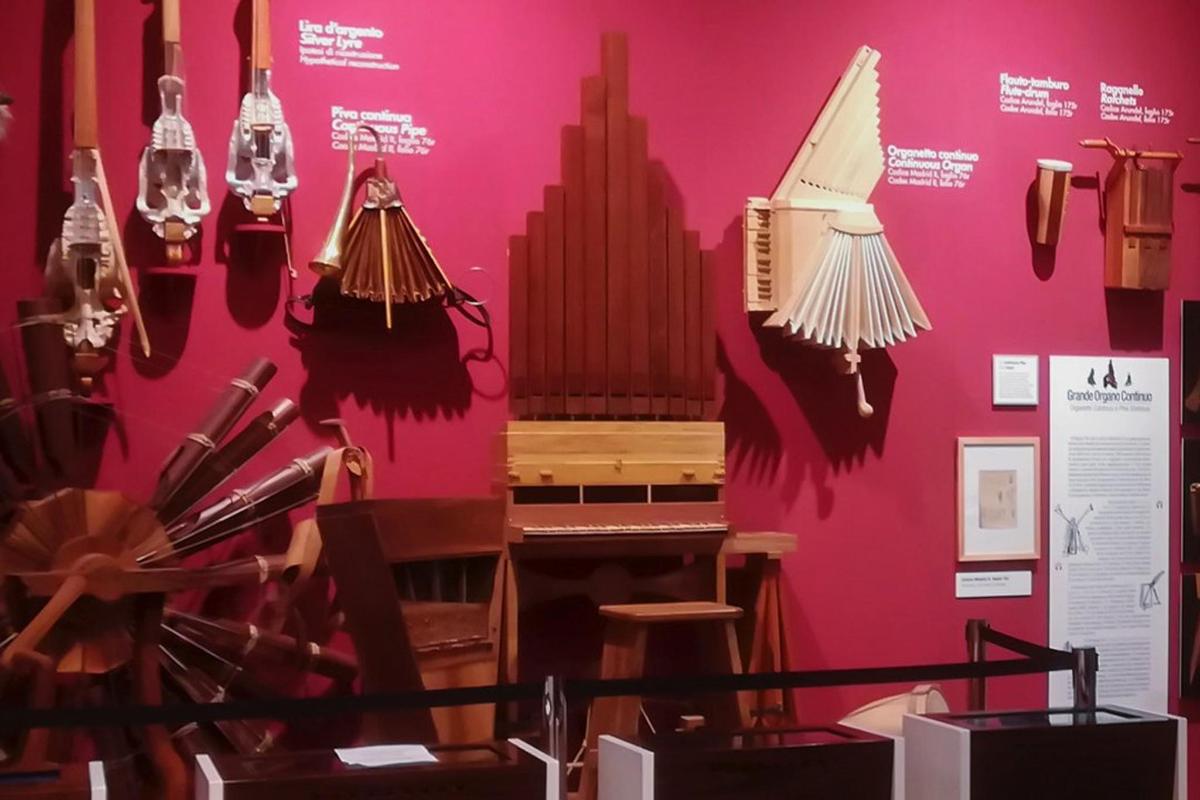 một màn trưng bày trong bảo tàng với một cây đàn piano và đèn chùm