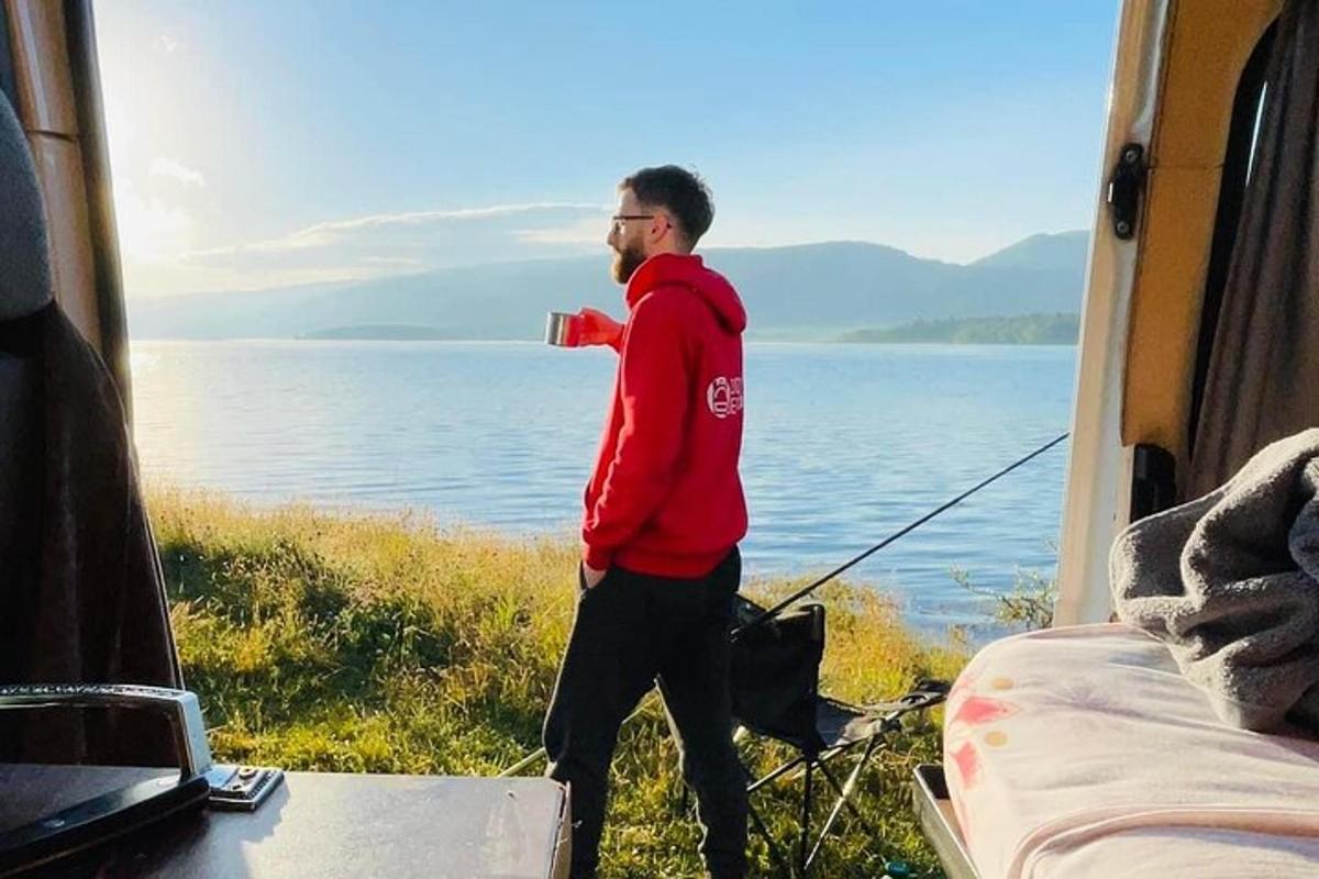 a man standing in the back of a tent next to the water
