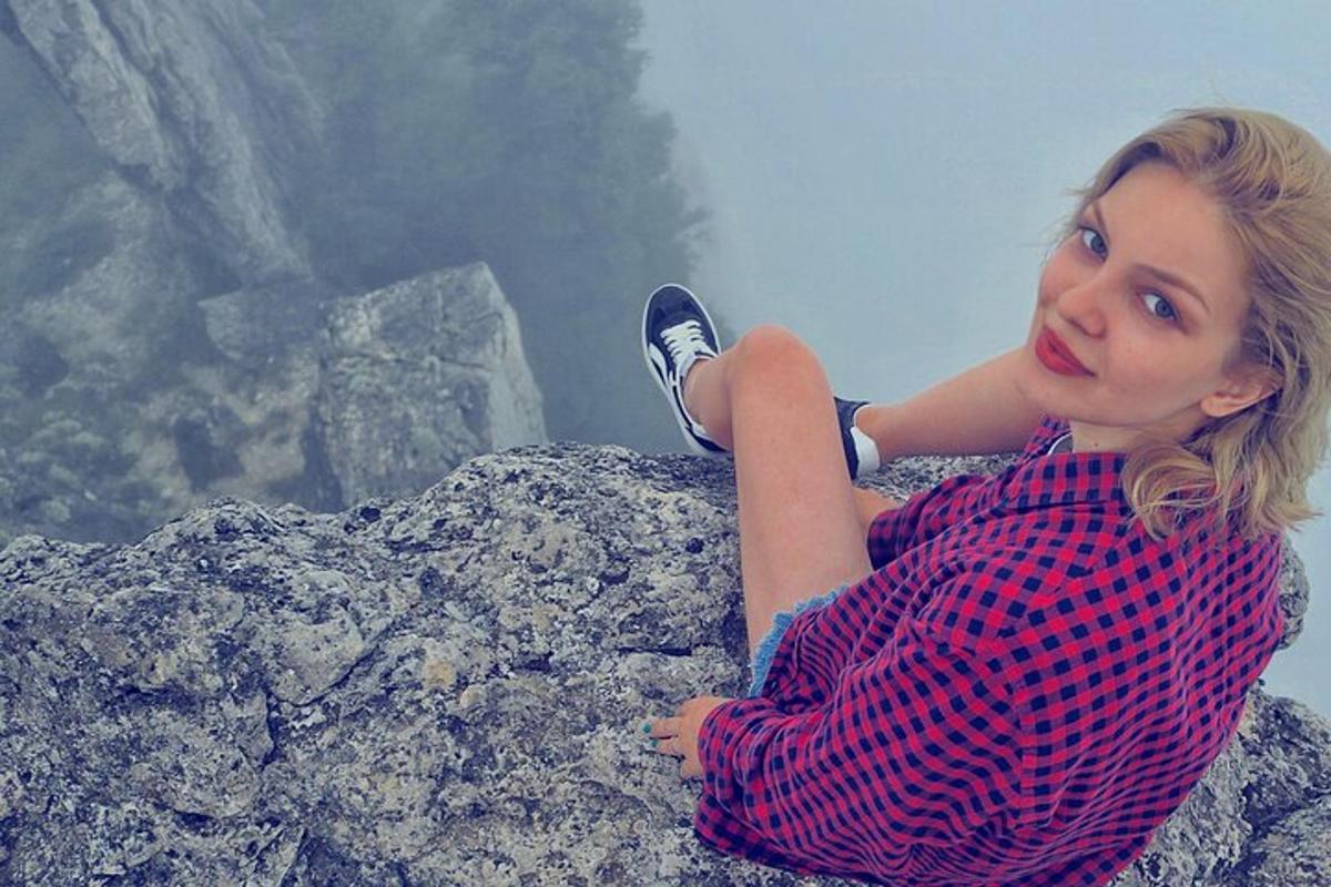 a woman sitting on top of a rock