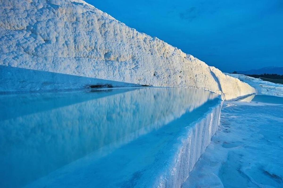 una pared de hielo con un reflejo en el agua
