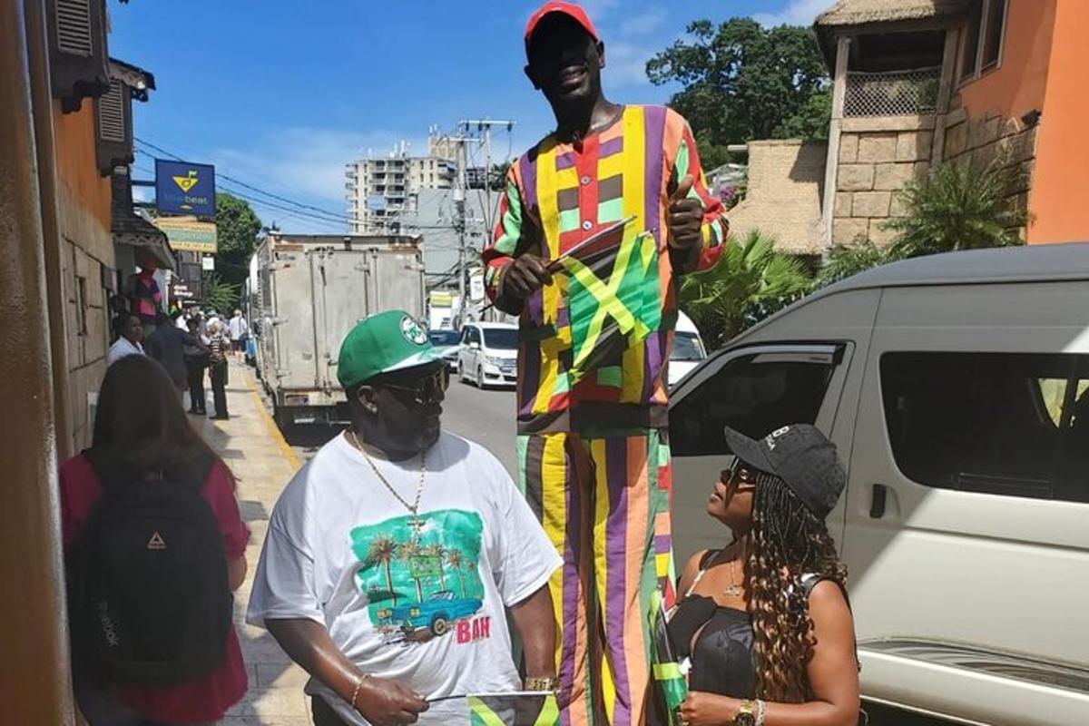 um homem parado ao lado de uma estátua de um homem parado ao lado de uma rua