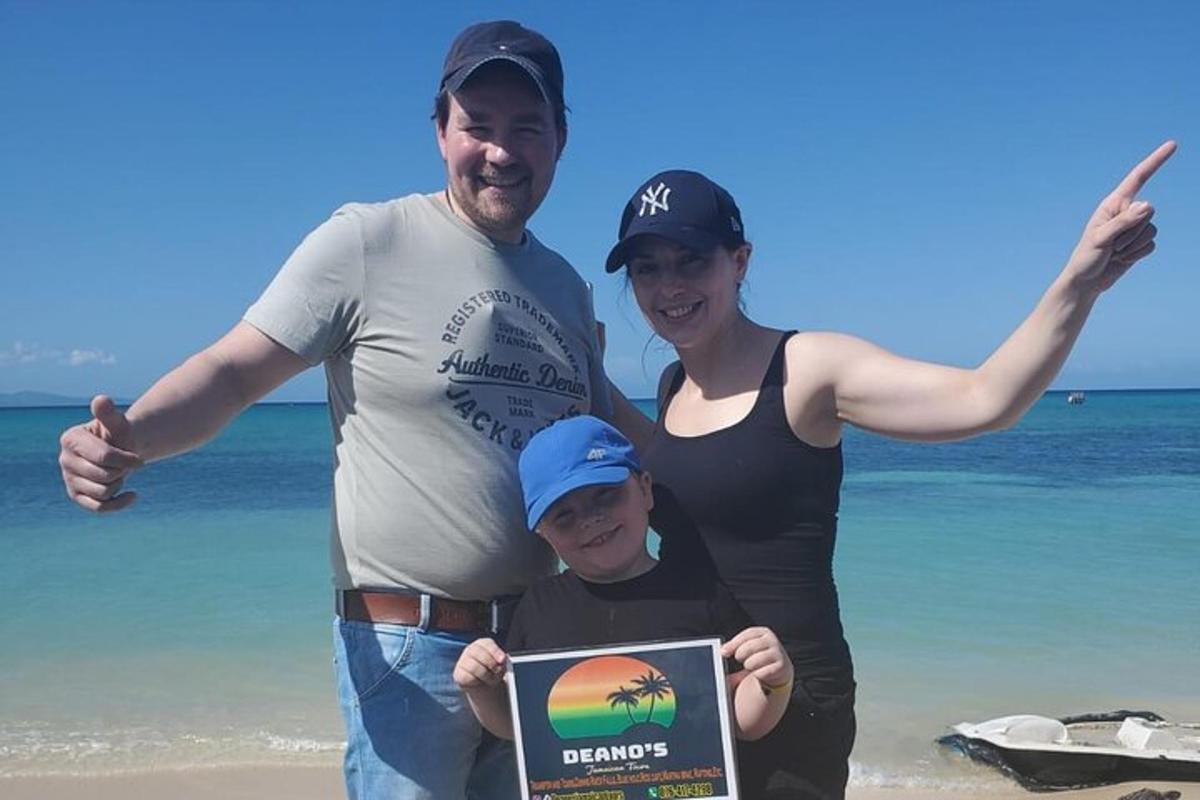 en mann og en kvinne som står på stranden med et barn