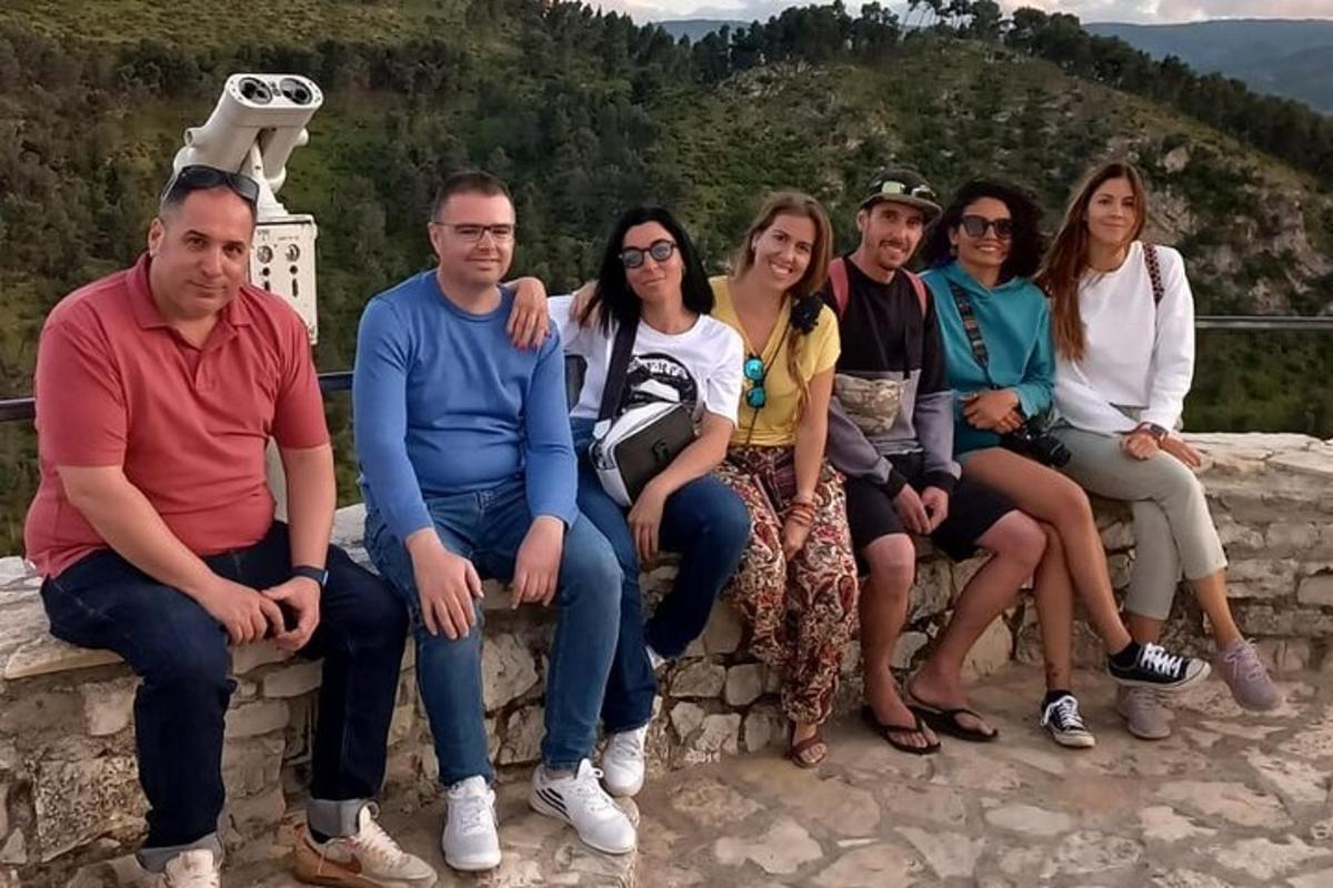 skupina ljudi, ki sedijo na kamnitem zidu