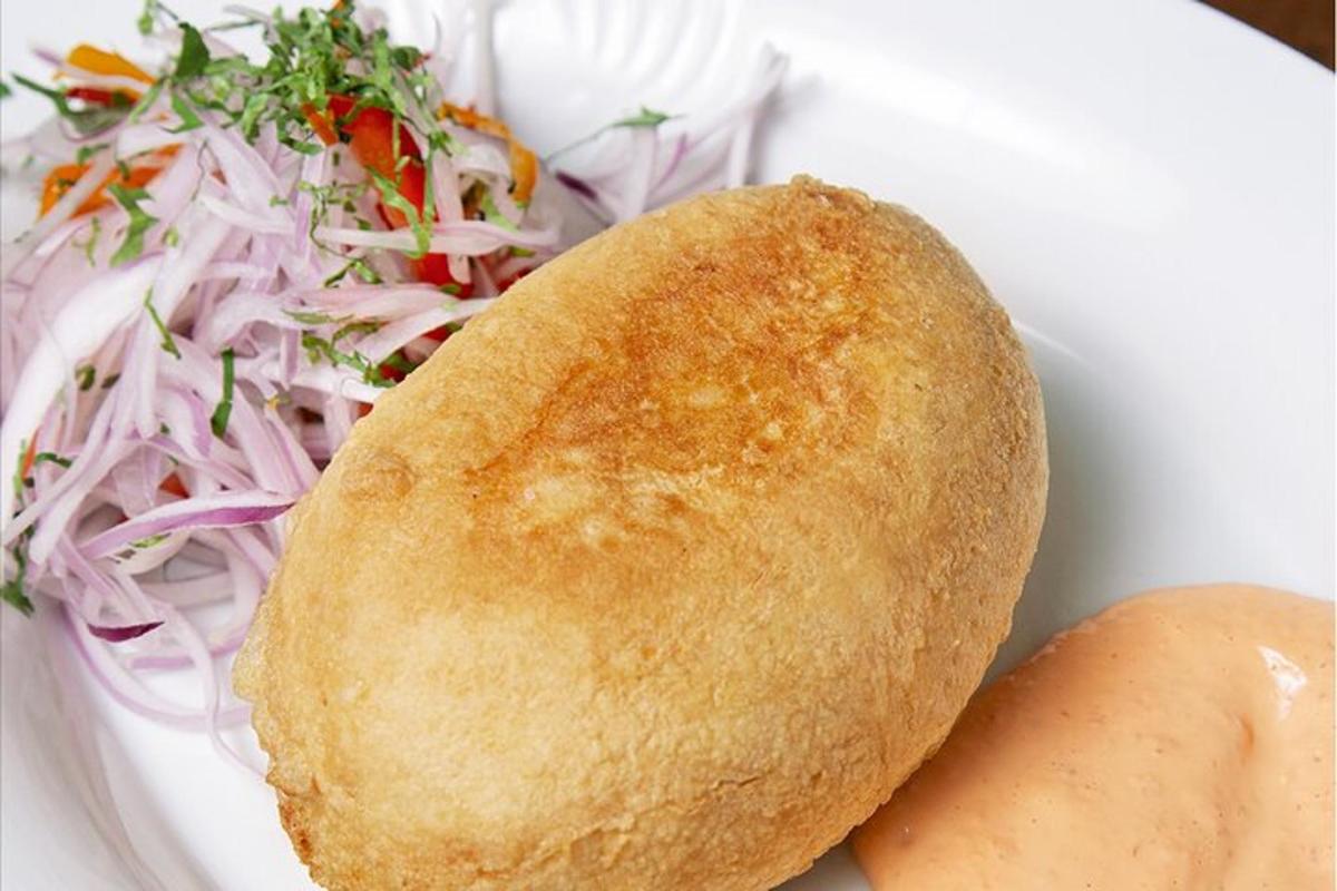 um prato branco com um sanduíche e uma salada