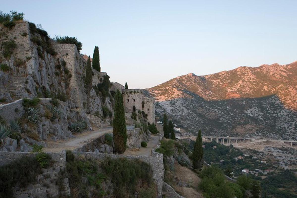 ένα παλιό κτίριο σε ένα βουνό με δέντρα πάνω του