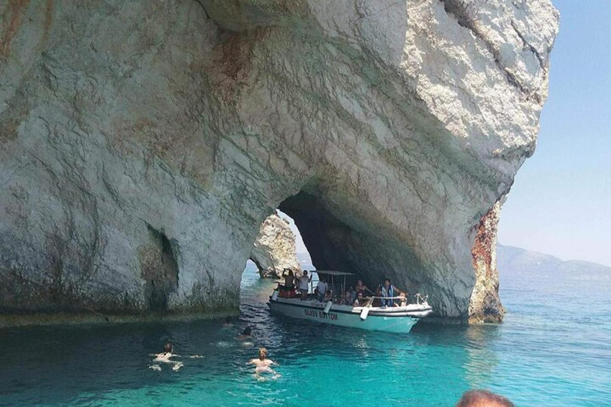 Un grupo de personas en un barco frente a una cueva.