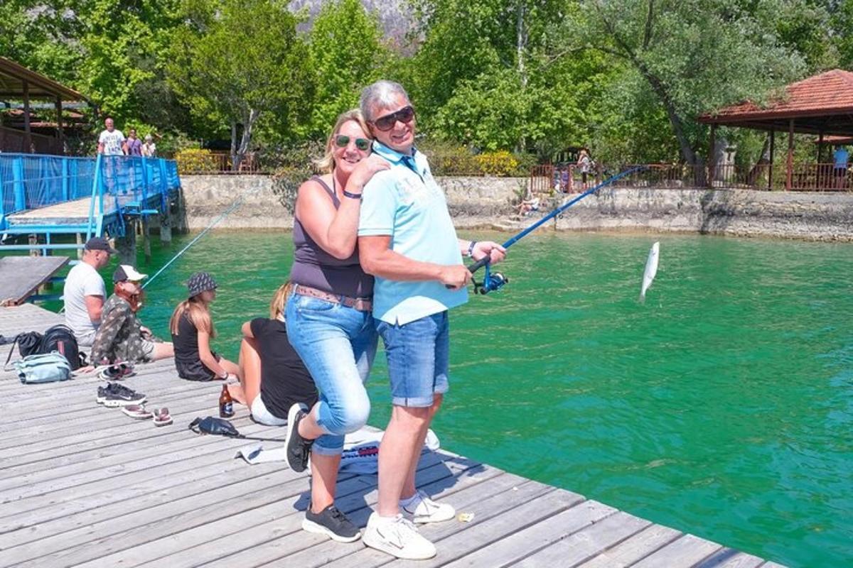 a man and a woman standing on a dock fishing