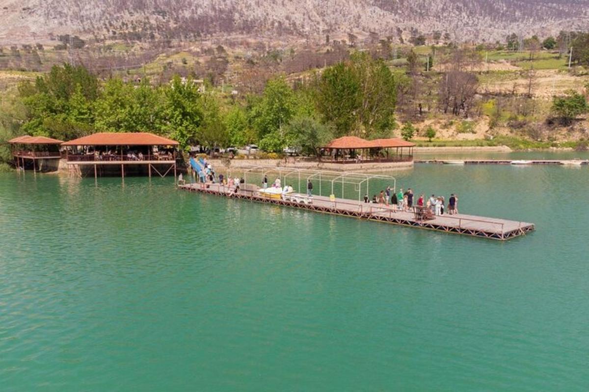 people standing on a dock in the middle of a lake