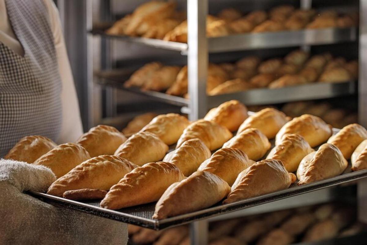 a bunch of bread on trays in a bakery