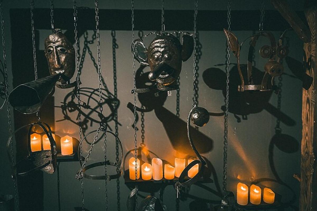 a group of masks hanging from a wall with candles