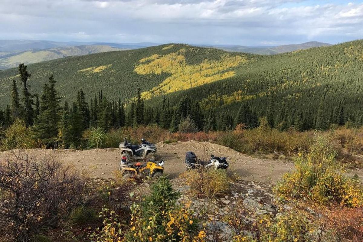 skupina motornih koles, parkiranih na hribu v gorah