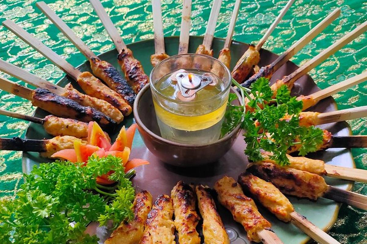 a plate of food with skewers and a drink