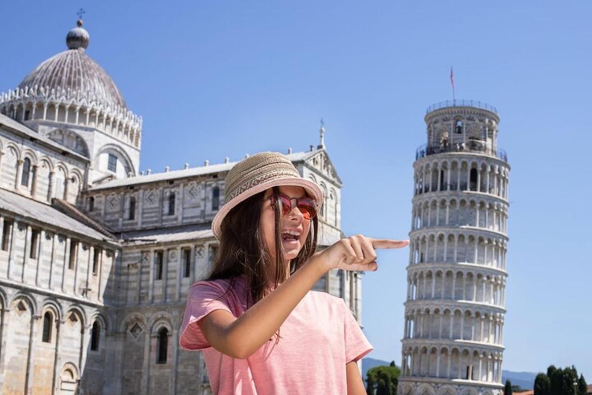 una ragazza che indica la torre pendente di Pisa