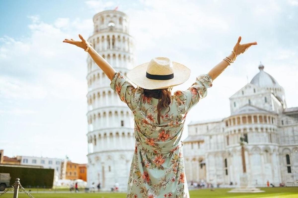 una donna con un cappello in piedi davanti alla torre pendente