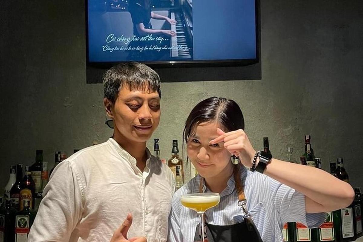 a woman standing next to a man holding a wine glass