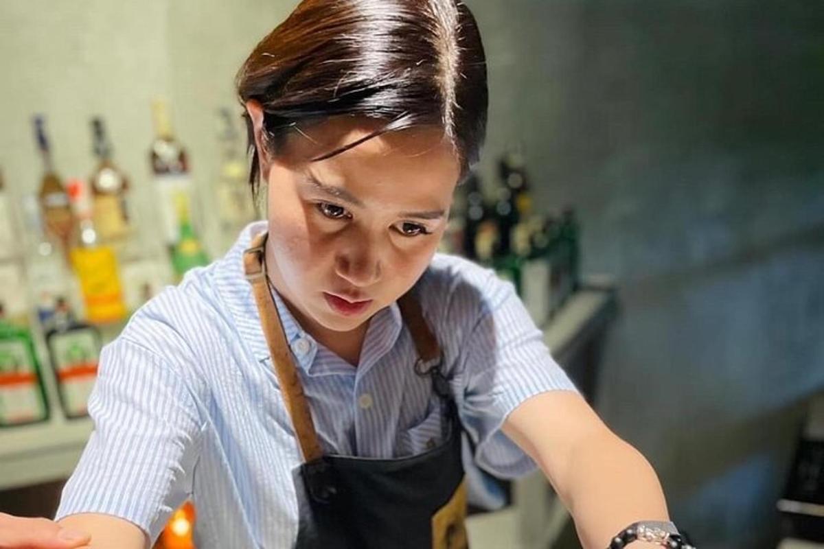 a young woman wearing an apron in a kitchen