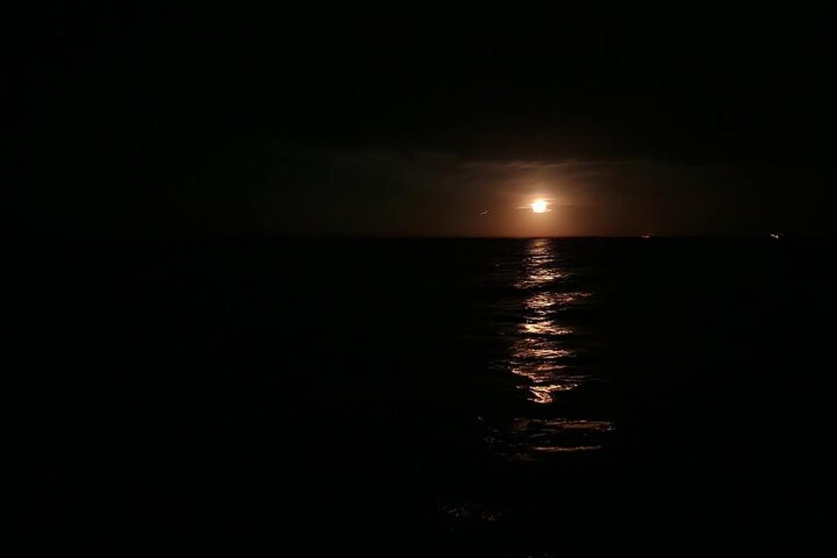 un răsărit de lună peste ocean noaptea