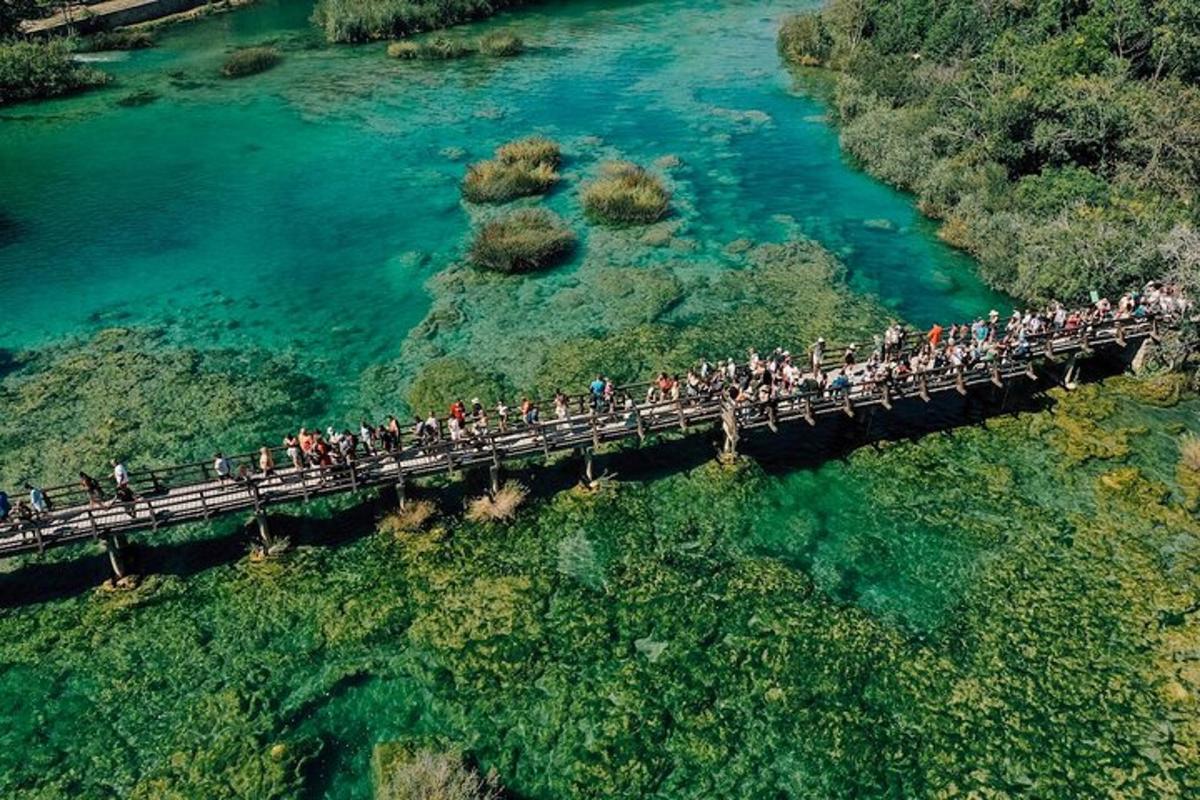 a group of people crossing a bridge over a river