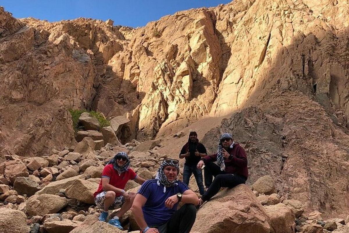 sekelompok orang duduk di atas batu di ngarai