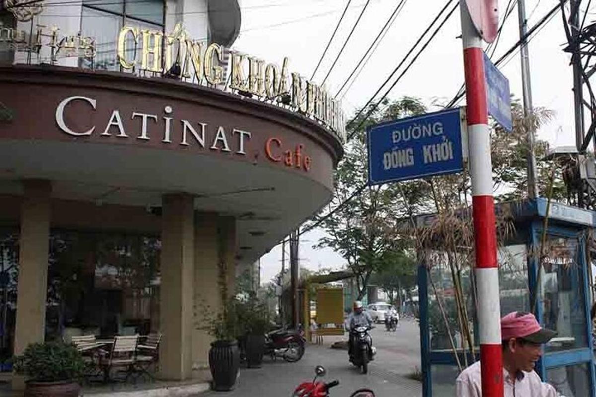 a street sign in front of a restaurant with people riding motorcycles