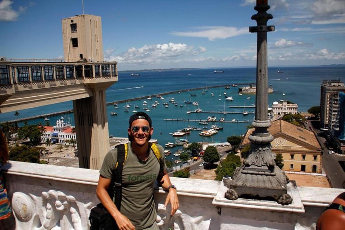 a man standing on a ledge with a view of a harbor