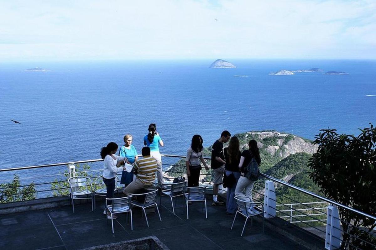 un gruppo di persone in piedi su un balcone che guarda l'oceano
