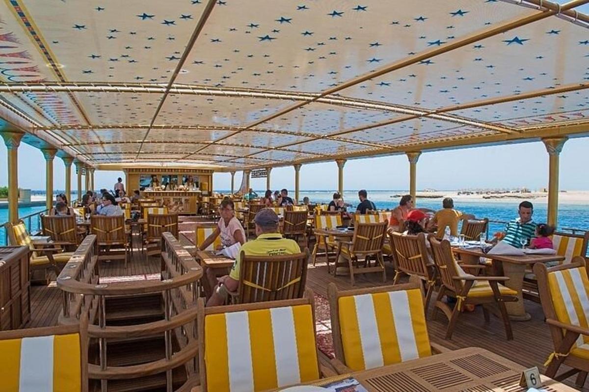 lidé sedící u stolů v restauraci na pláži