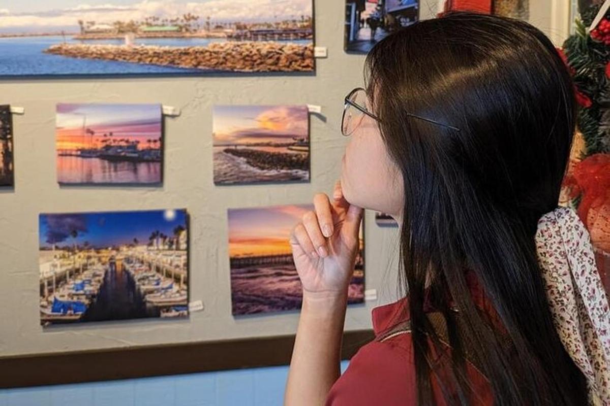 a woman looking at photographs on a wall