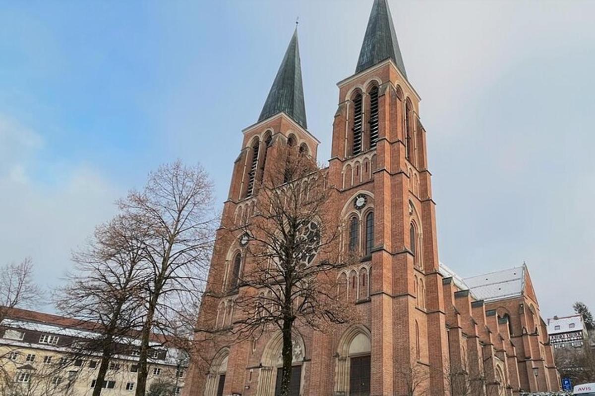 uma grande igreja de tijolos com duas torres e uma árvore