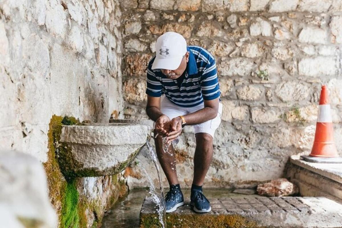 a man sitting on a water fountain with his foot
