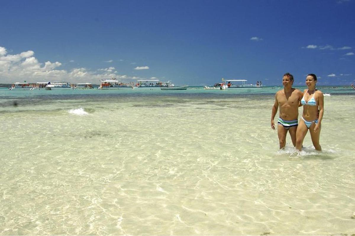 two people standing in the water on a beach