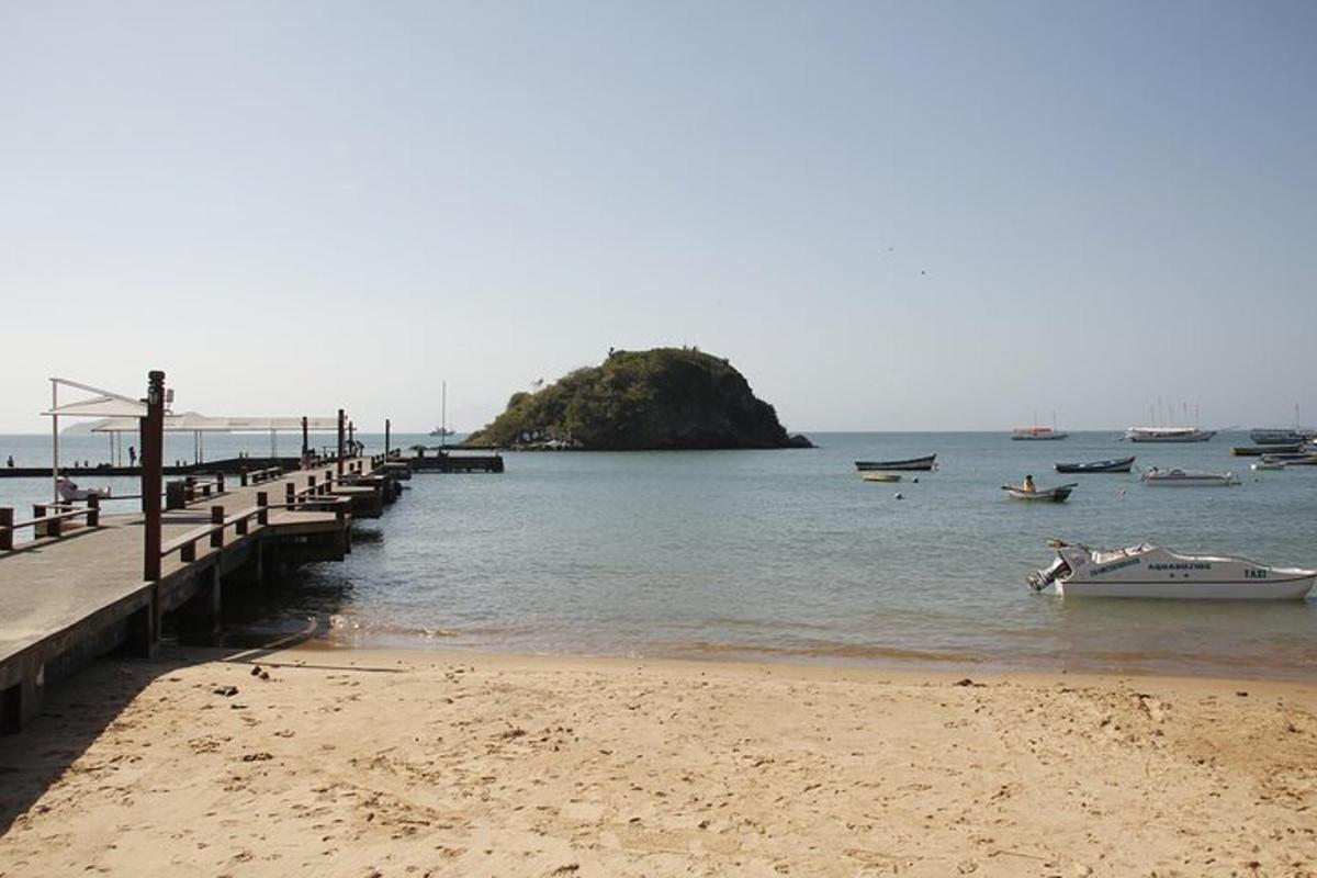 a beach with a pier and boats in the water