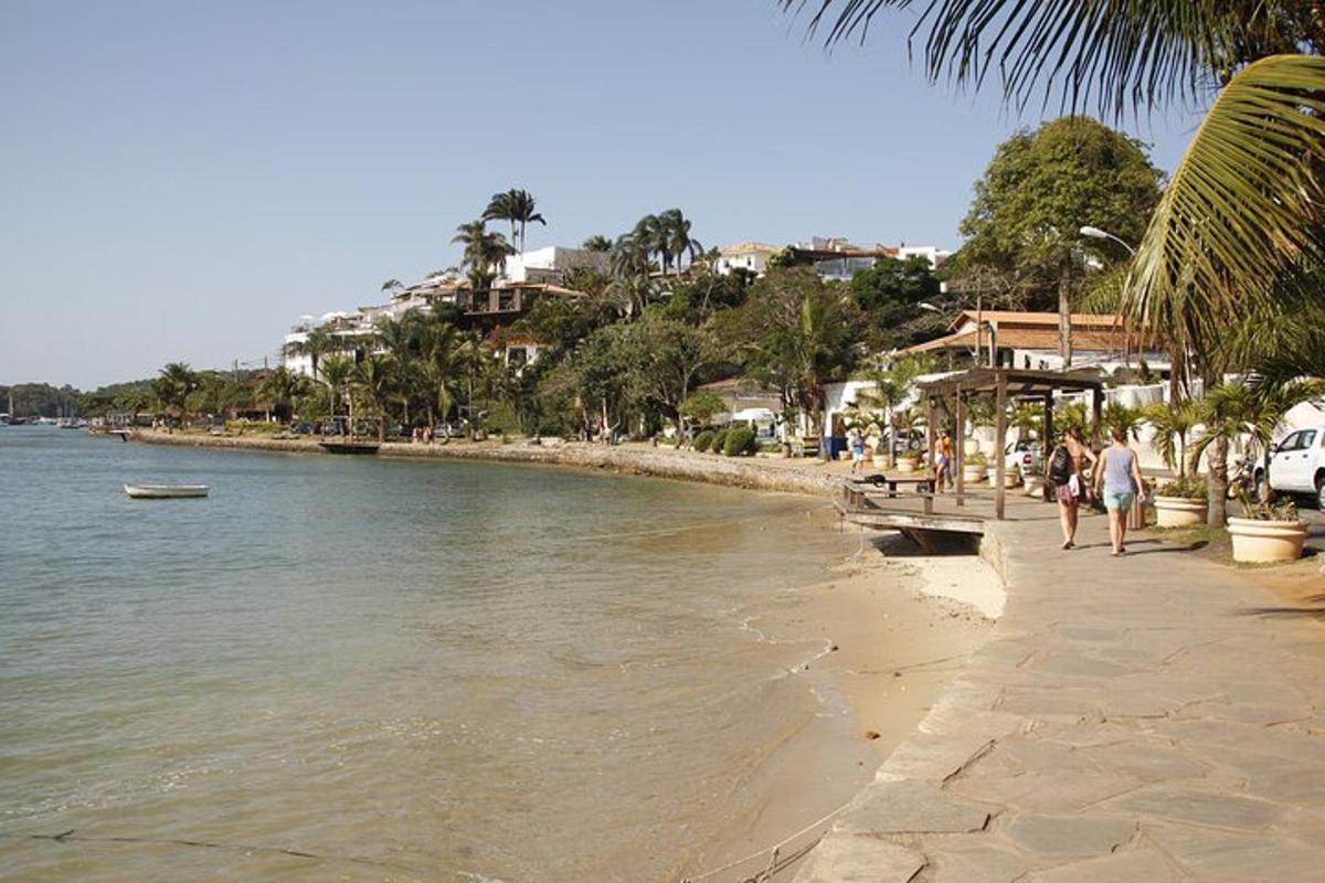 a group of people walking on a beach next to the water