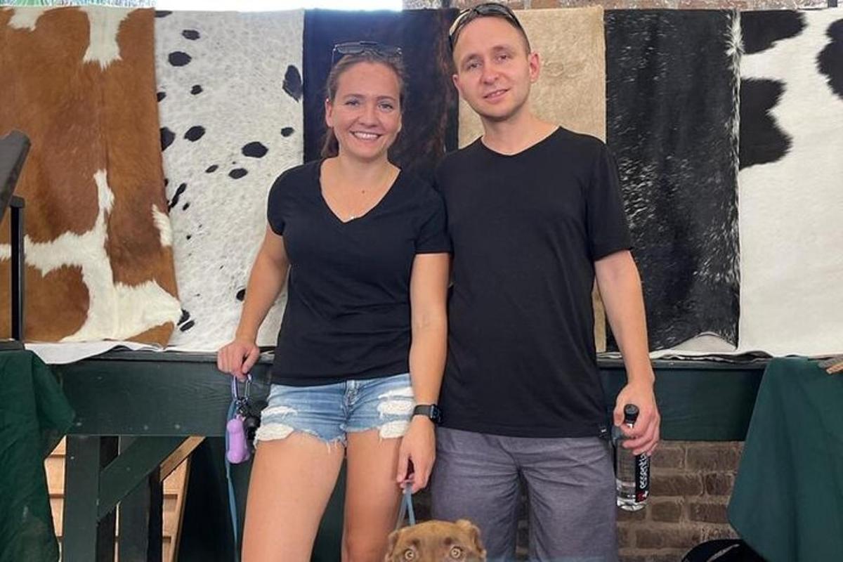 un uomo e una donna in piedi accanto a un cane